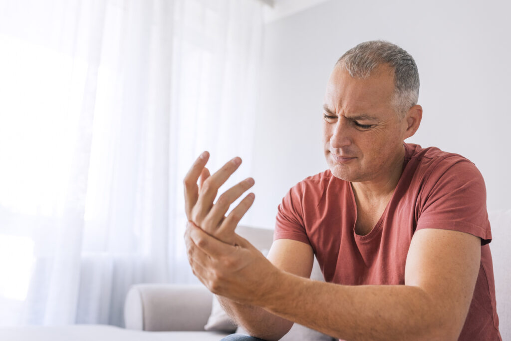 A man clenching his painful hand