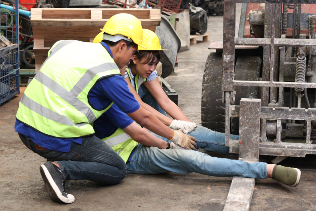 Workers helping a colleague who’s been struck by a forklift