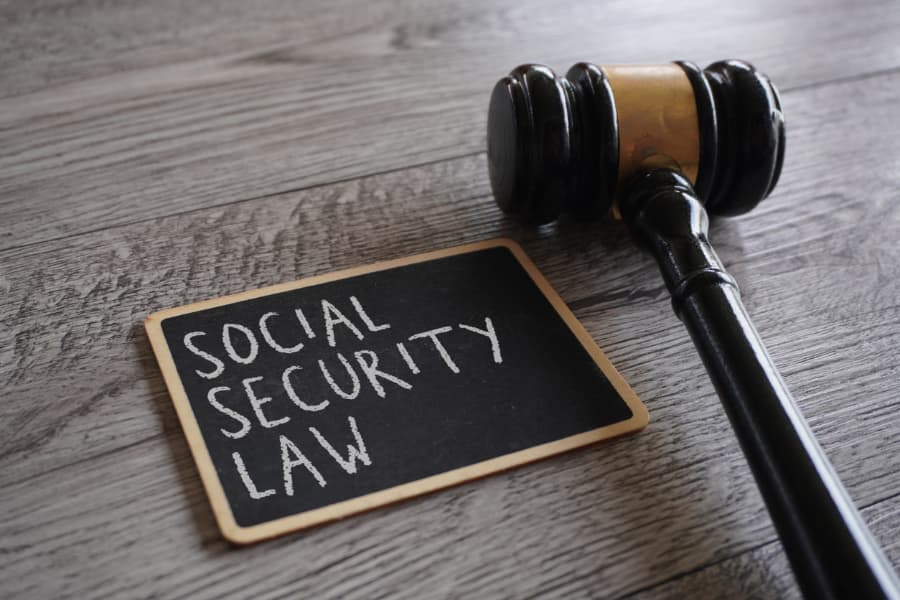 Close-up of a gavel and chalkboard with “Social Security Law” written on it