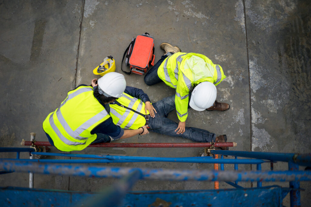 Aerial view of construction workers helping a man who has fallen from scaffolding