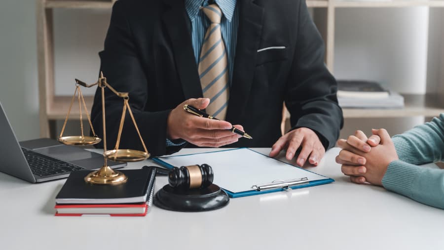 Close-up of SSDI lawyer with pen and clipboard consulting with female client